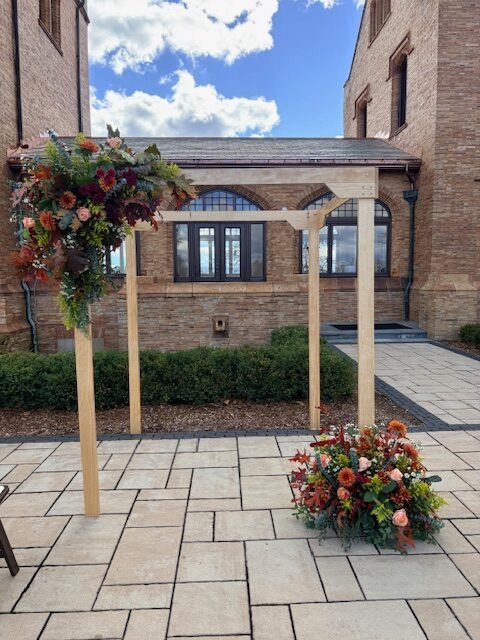 picture of a wood chuppah decorated with flowers for a wedding